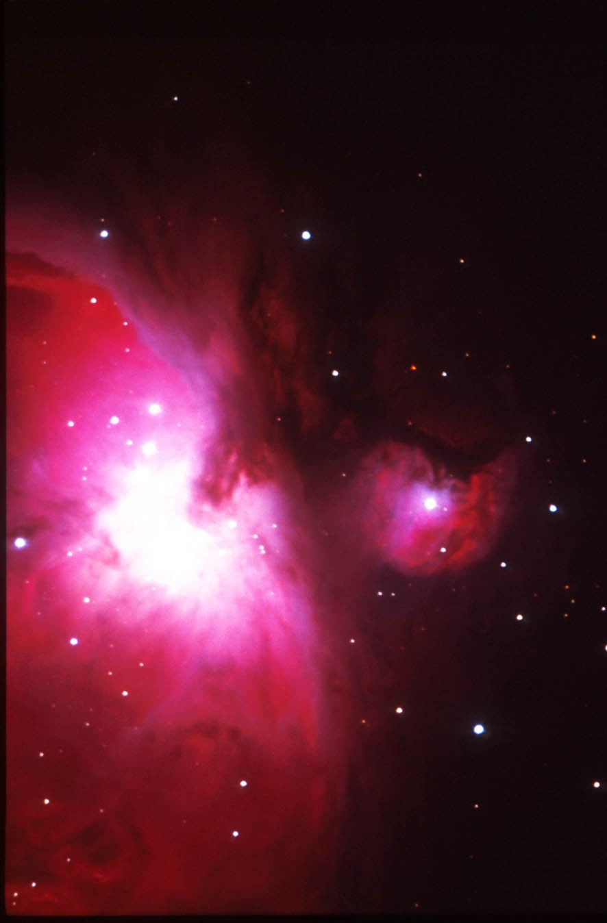 La Grande Nebulosa di Orione si trova nella spada dell'omonima costellazione. Si trova ad una distanza di circa 1500 anni luce, cioè la vediamo com'era e dov'era 1500 anni fa (oppure, se qualcuno potesse vederci a quella distanza, vedrebbe i risultati delle invasioni barbariche sulla nostra penisola). La nebulosa è formata da una distesa di diversi anni luce di gas, per lo più idrogeno, in gran parte meno denso di un buon vuoto di laboratorio. Dove questo gas si concentra, grazie all'attrazione gravitazionale, si formano le stelle. Al suo interno ce ne sono quasi un migliaio, quasi tutto giovanissime (qualche milione di anni d'età!). Sono proprio le radiazioni emesse da queste (in particolare quelle nell'ultravioletto) che "eccitano" il gas della nebulosa, che emette di conseguenza energia luminosa. (testo e foto P.Ochner)