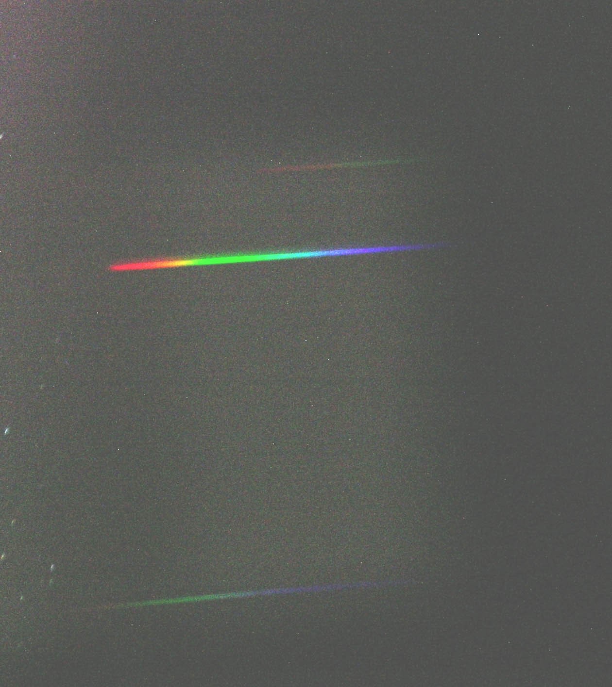 Con un prisma e una macchina fotografica digitale è possibile ottenere lo spettro delle stelle. Ad occhio nudo quasi tutte le stelle sembrano bianche; in realtà la loro luce contiene tutti colori dell'arcobaleno (spettro). Il bianco in realtà non esiste, è una nostra percezione ottenuta quando la nostra retina è colpita da tutti i colori dell'acobaleno (anche se in realtà sono sufficienti il rosso, il verde e il blu). Il prisma è un vetro a forma di piramide che è in grado di separare la luce bianca nei suoi componenti. Ponendo una macchina fotografica vicino ad esso - il tutto posto naturalmente su un cavalletto - è possibile registrare l'immagine di uno spettro stellare. È in questo modo che gli astronomi ricavano le caratteristiche delle stelle: temperatura, composizione, velocità, ecc. Ogni spettro di una stella è diverso dagli altri: su di esso si trovano delle righe nere che sono una specie di impronta digitale dell'astro. Nell'immagine lo spettro della Stella Polare. (testo e immagine Ochner)